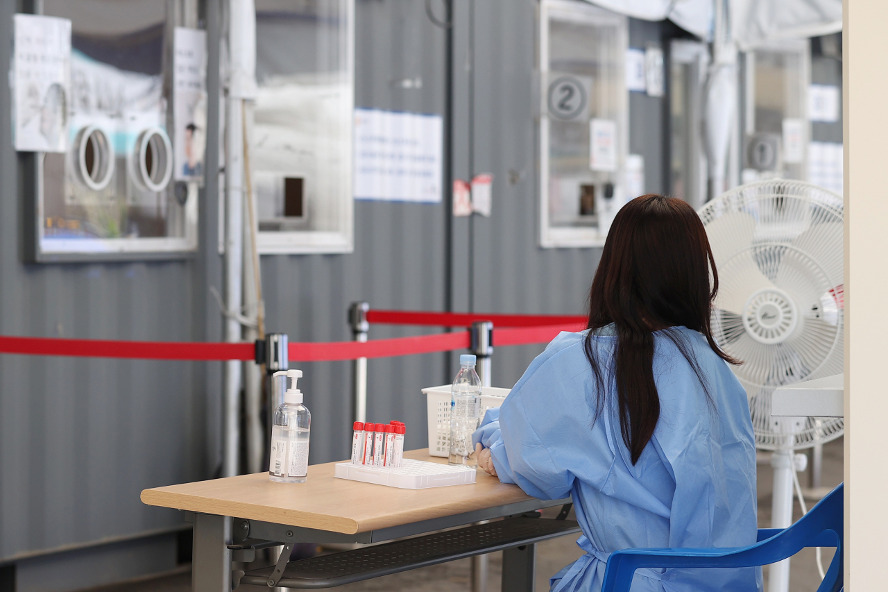 A medical worker sits at a makeshift COVID-19 testing station in Seoul last Monday. (Yonhap)
