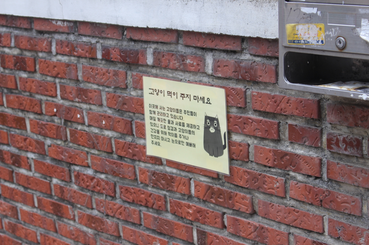A sign in Nogosan-dong, Seoul warns people not to feed stray cats, saying the cats are taken care of by the residents in the area. (Yoon Min-sik/The Korea Herald)