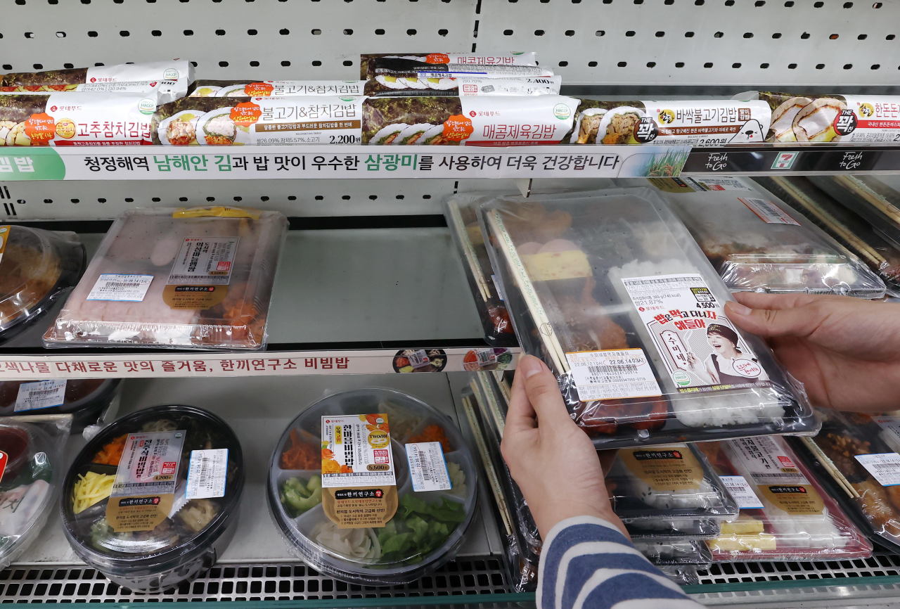 A 7-Eleven employee arranges lunchbox products at a 7-Eleven convenience store in Jung-gu, Seoul. (Yonhap)