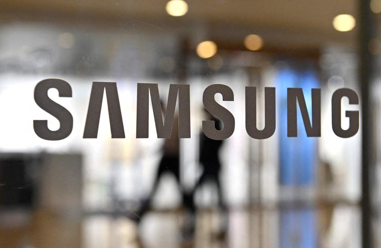 People walk past the Samsung logo displayed on a glass door at the company‘s Seocho building on Jan. 7 in Seoul. (AFP-Yonhap)