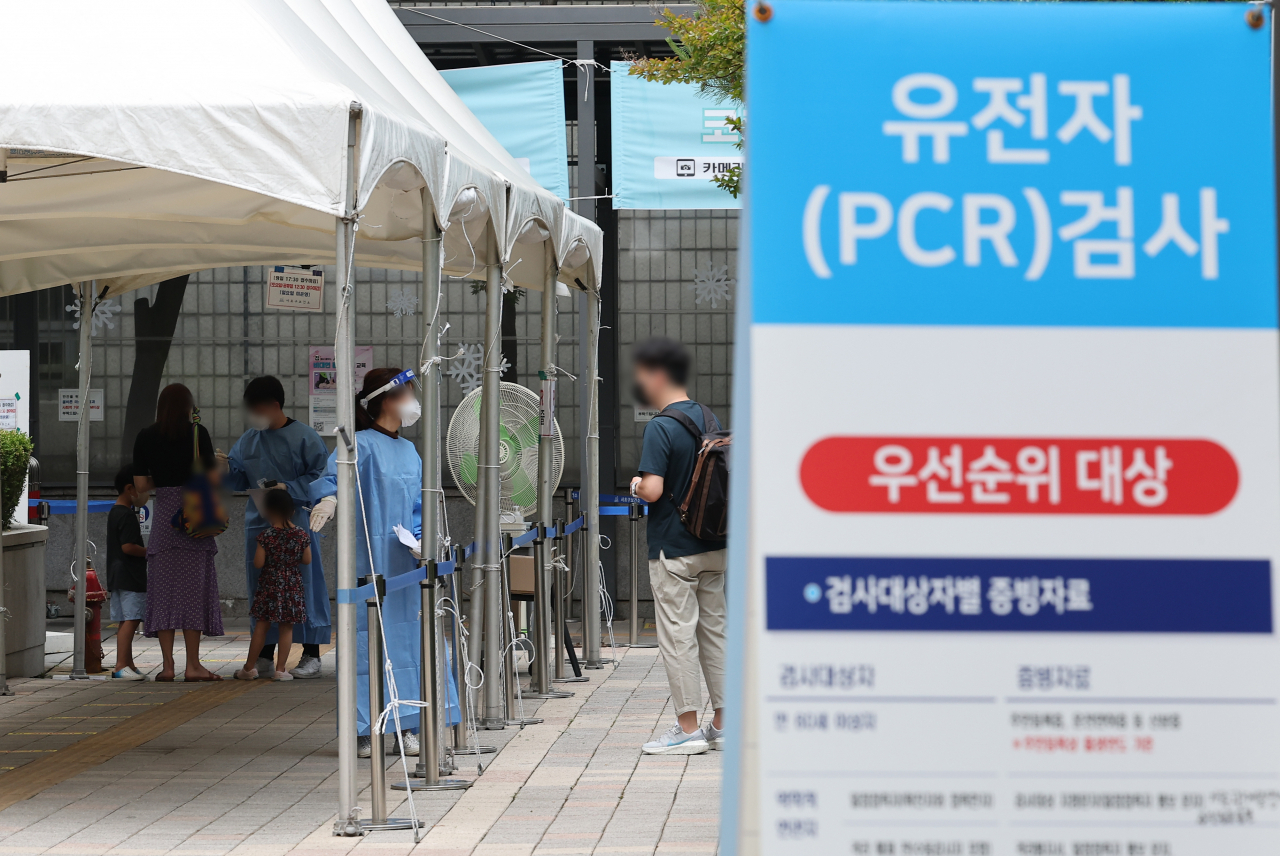 A health worker guides a visitor at a COVID-19 testing station in Seoul's southern district of Seocho last Friday. (Yonhap)