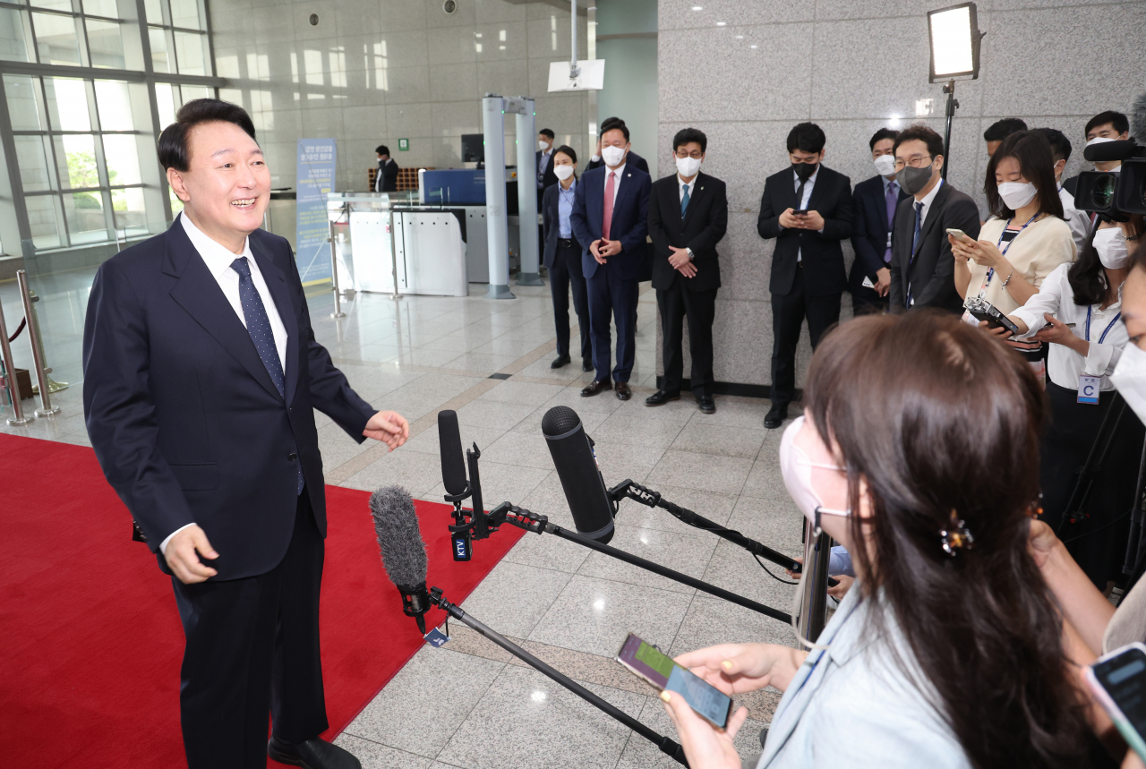 President Yoon Suk-yeol takes reporters' questions as he arrives at his office in Seoul on Tuesday. (Yonhap)