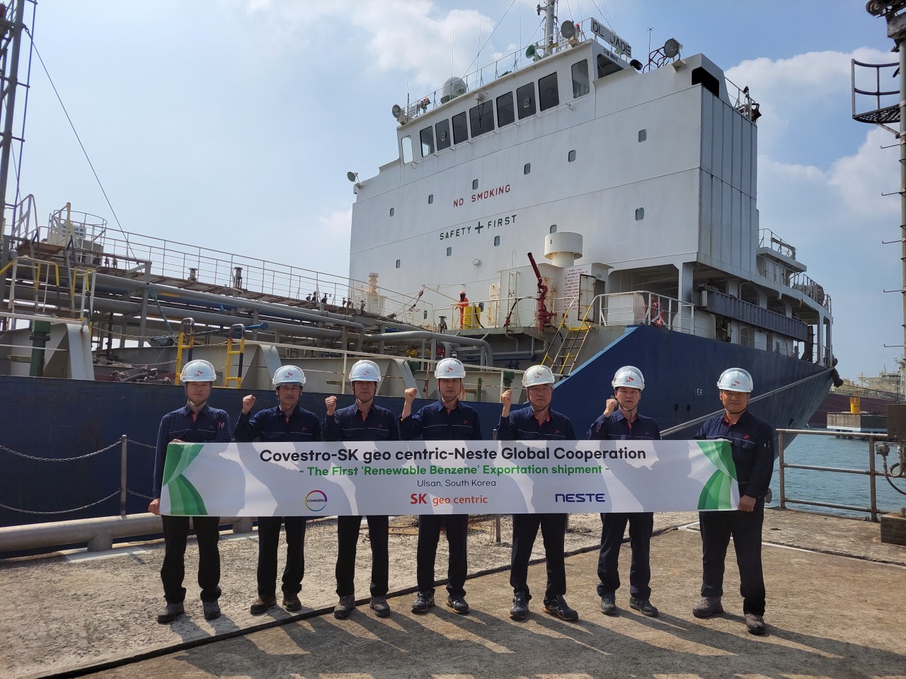 SK Geo Centric employees hold up a banner at the Ulsan CLX SK Port on June 14 marking the first shipment of renewable benzene to Covestro factories in China. (SK Geo Centric)