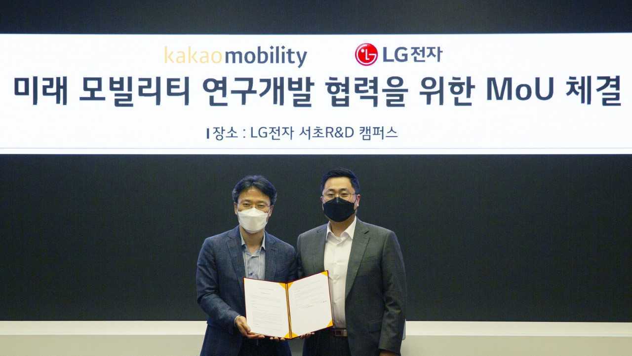 LG Electronics Chief Technology Officer Kim Byung-hoon (left) and Kakao Mobility Chief Technology Officer Yoo Seung-il pose after a signing event for the two companies’ partnership on future mobility services at an LG research center in Seoul. (LG Electronics)