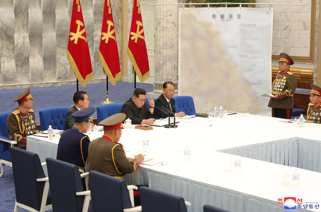 리태섭 조선인민군 총참모장이 남측 동해안 지도 앞에 서 있는 북한 지도자에게 브리핑을 하고 있다.  흐릿한 지도는 국영 조선중앙통신이 제공한 이 사진에서 북한의 원산에서 남한의 포항까지의 지역을 보여줍니다.  (연합)