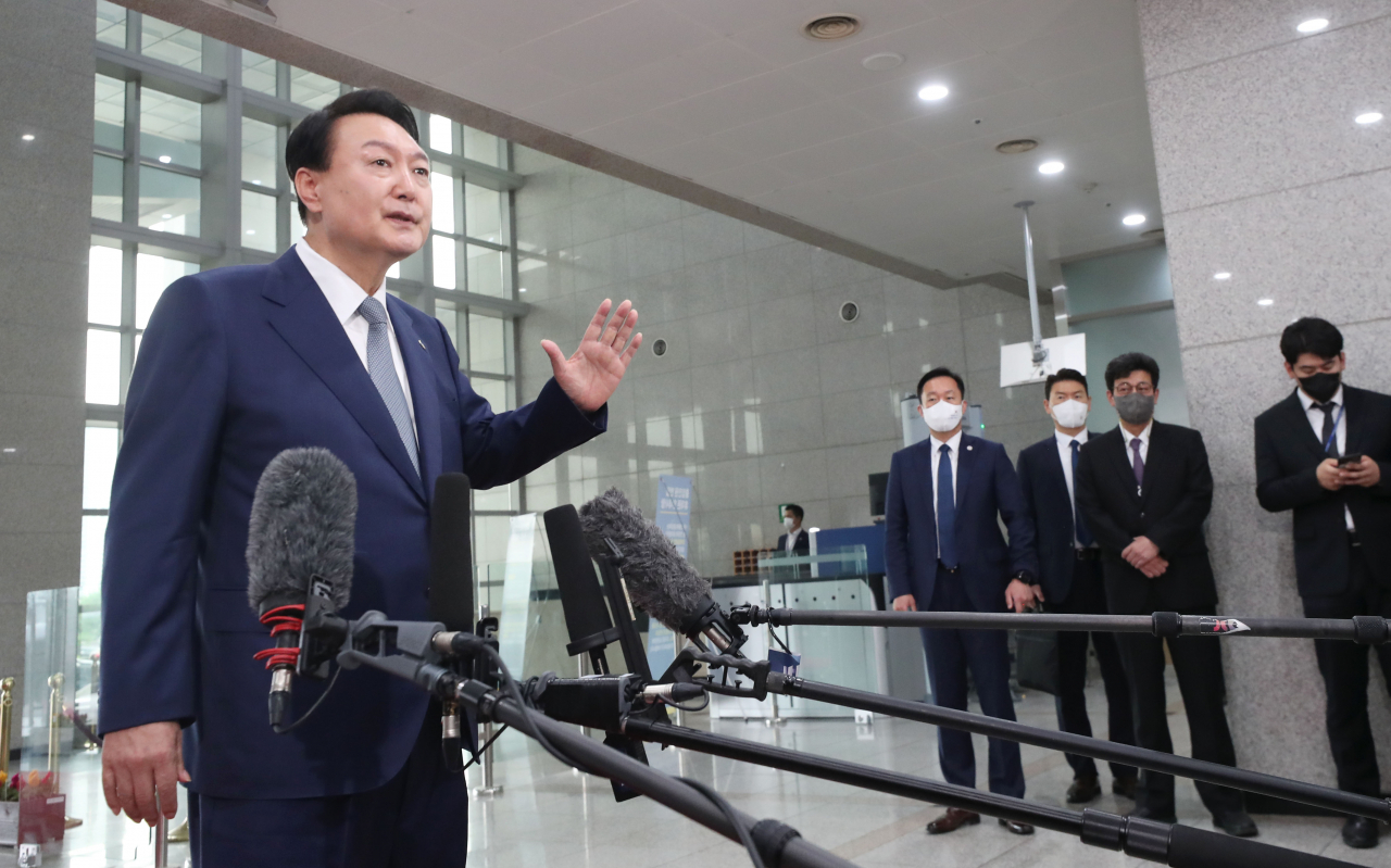 President Yoon Suk-yeol takes reporters' questions as he arrives at his office in Seoul on Friday. (Yonhap)