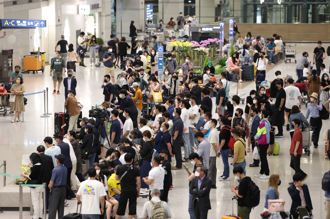 People wait at a gate for international arrivals, in Incheon International Airport, Thursday. (Yonhap)