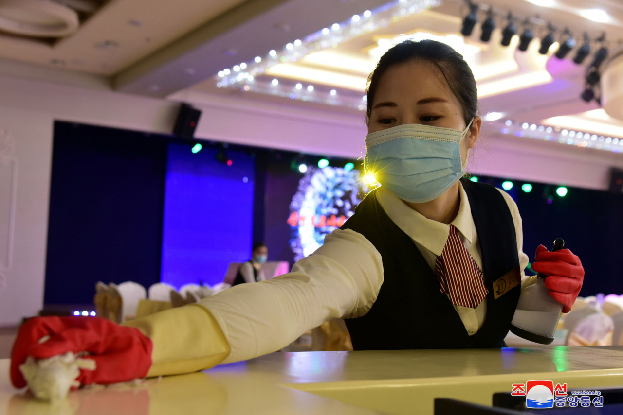 An employee of Ryugyong Golden Department Store in Pyongyang carries out disinfectant work, in this file photo released by the North's Korean Central News Agency last Wednesday. (KCNA)