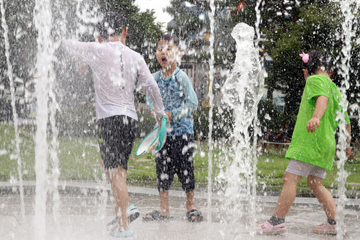 Children play in a fountain in the southern city of Jeonju on Saturday, with the mercury rising above 30 C in many parts of the country. (Yonhap)