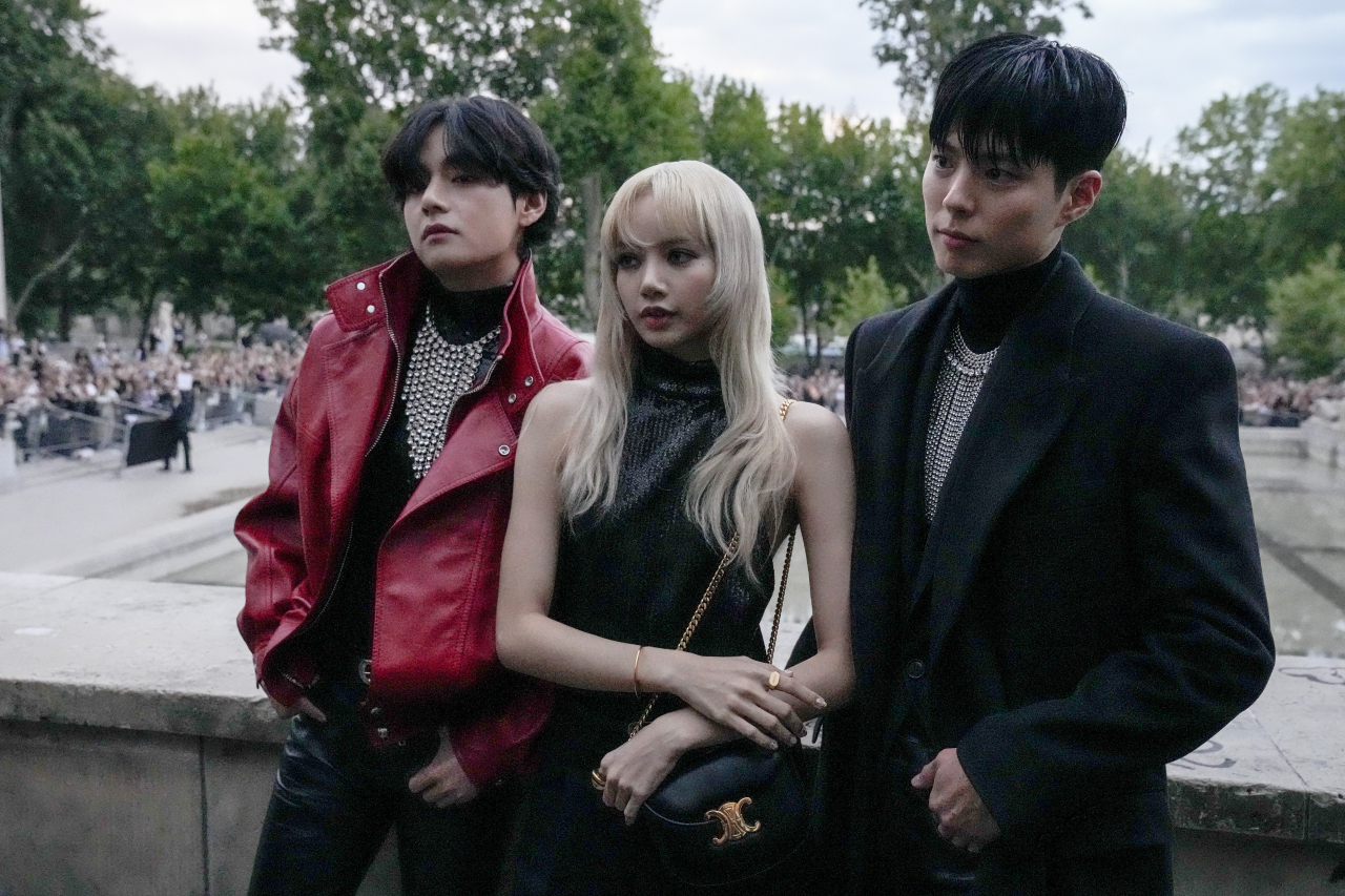 In this AP photo, K-pop stars V (C) of BTS and Lisa (R) of BLACKPINK attend a fashion show in Paris on Sunday. (AP)