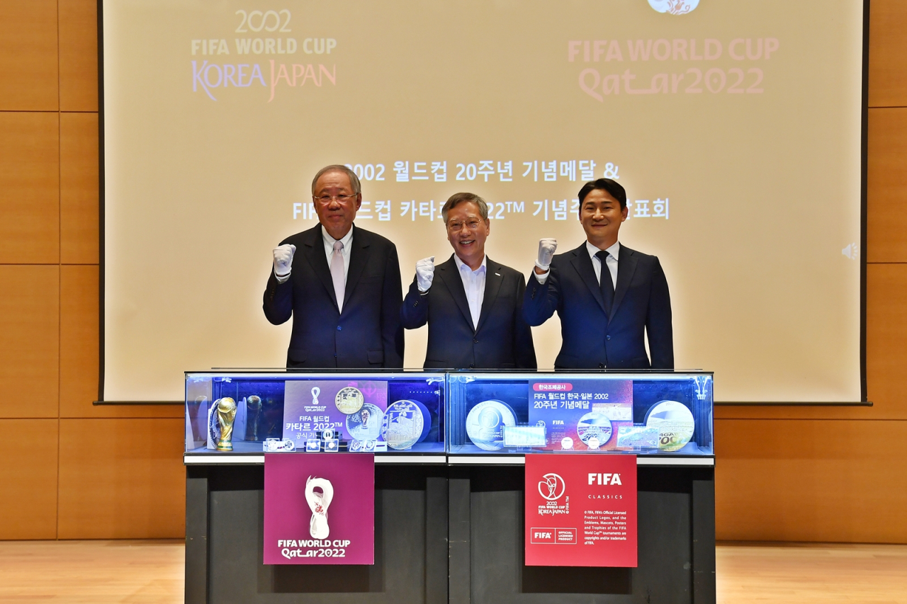 (From Left) Poongsan Group Chairman Ryu Jin, KOMSCO CEO Bahn Jahng-Shick, and former South Korean footballer Lee Chun-soo pose for a photo Monday at the Poongsan Group headquarters, located in Seodaemun-gu, Seoul, behind an exhibition showcasing the commemorative medals celebrating the 2022 Qatar World Cup (left), and the 20th anniversary of the 2002 Korea, Japan World Cup (right). (KOMSCO)