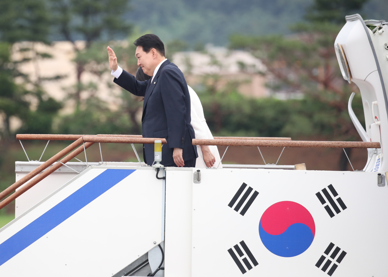 South Korean President Yoon Suk-yeol waves at Seoul Air Base in Seongnam on Monday, ahead of his five-day trip to Spain to attend the NATO summit on his first overseas trip as president.(Yonhap)