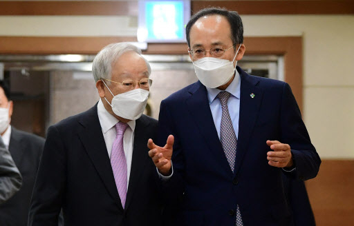 Finance Minister Choo Kyung-ho (R), who doubles as the deputy prime minister for economic affairs, talks with Sohn Kyung-shik, head of the Korea Employers Federation (KEF), while walking to a KEF meeting room in Seoul on Tuesday. (Yonhap)