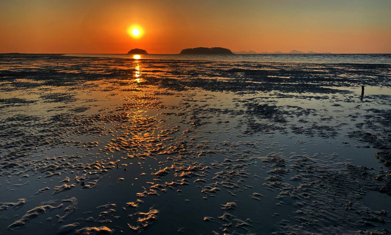 The sun sets over the Sojukdo (left) and Daejukdo in the West Sea off the Gochang Getbol Tidal Flats, which are listed on the UNESCO World Heritage convention for exhibiting a complex combination of geological, oceanographic and climatologic coastal diverse sedimentary systems. Photo © Hyungwon Kang
