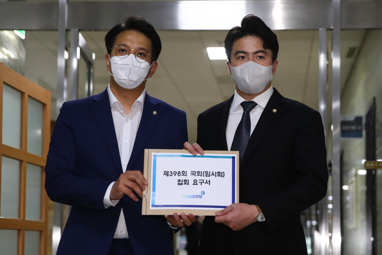 Reps. Jeon Yong-gi (left) and Oh Yeong-hwan (right) of the Democratic Party of Korea pose for a photo Tuesday as they submit a request to the National Assembly to open a provisional assembly in July. (Joint Press Corps)