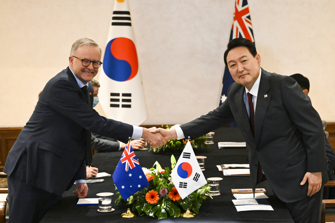 South Korean President Yoon Suk-yeol (R) poses for a photo with Australian Prime Minister Anthony Albanese as they meet on the sidelines of the North Atlantic Treaty Organization summit in Madrid on Tuesday. (Yonhap)