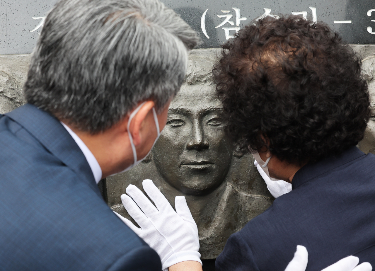 A bereaved mother touches the sculpture of her son, who died during an inter-Korean naval skirmish near the western sea border two decades ago, at the Navy's Second Fleet in Pyeongtaek, 70 kilometers south of Seoul, on Wednesday. (Yonhap)