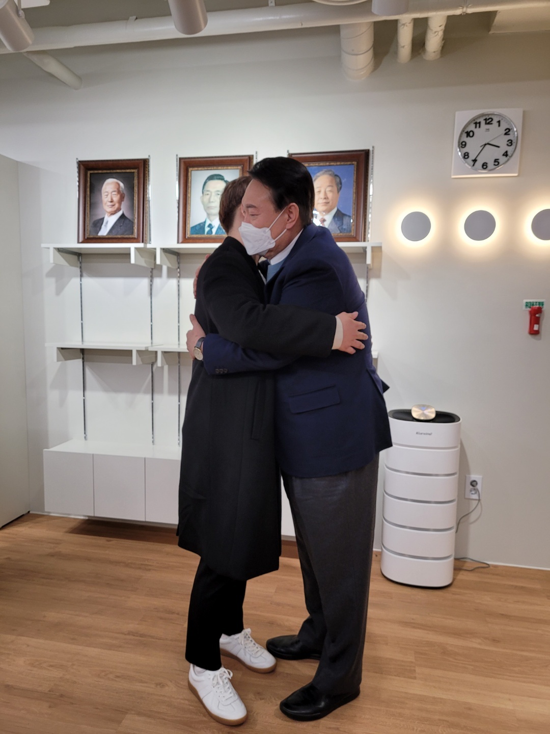 In this photo, Yoon Suk-yeol, then a presidential candidate, hugs the son of the slain fisheries official at an office in Yeouido, central Seoul, on Jan. 31. (Courtesy of Lee’s family)