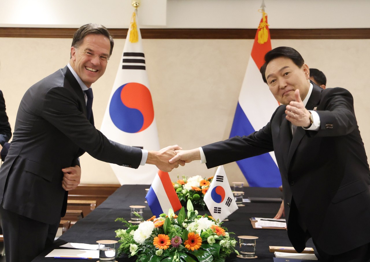 South Korean President Yoon Suk-yeol (R) poses for a photo with Dutch Prime Minister Mark Rutte as they meet on the sidelines of a meeting of the North Atlantic Treaty Organization in Madrid on June 29, 2022. (Yonhap)