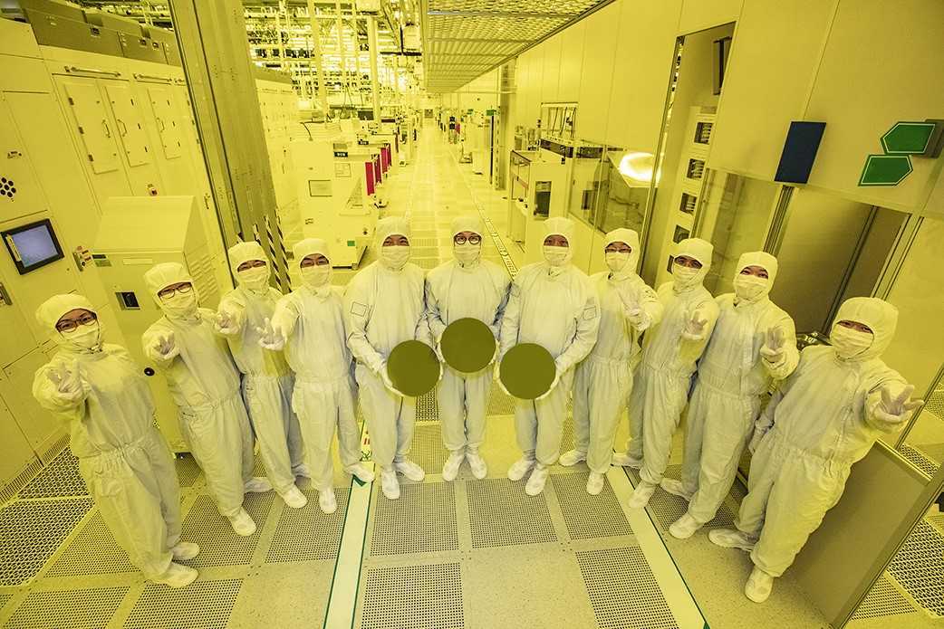 Samsung Electronics executives and researchers pose with semiconductor wafers, produced by 3-nm technology, at the company’s chip-making complex in Hwaseong, Gyeonggi Province, on Thursday. (Samsung Electronics)