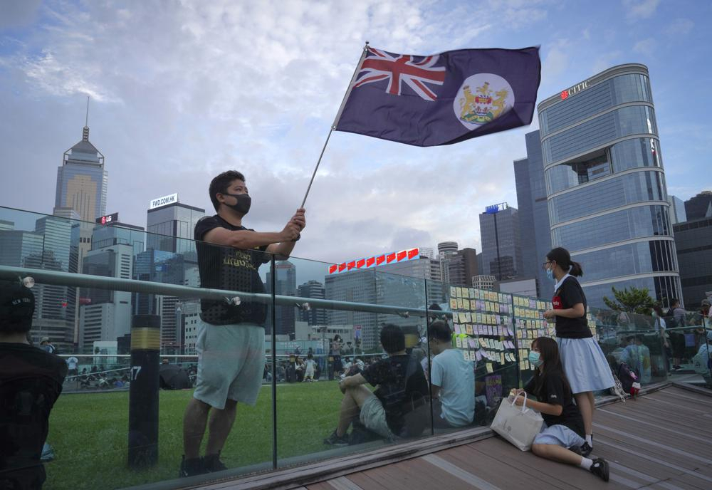 A protester waves Hong Kong British colony flag during continuing pro-democracy rallies in Tamar Park, Hong Kong, on Sept. 3, 2019. When the British handed its colony Hong Kong to Beijing in 1997, it was promised 50 years of self-government and freedoms of assembly, speech and press that are not allowed Chinese on the Communist-ruled mainland. As the city of 7.4 million people marks 25 years under Beijing's rule on Friday, those promises are wearing thin. Hong Kong's honeymoon period, when it carried on much as it always had, has passed, and its future remains uncertain, determined by forces beyond its control. (AP Photo/Vincent Yu, File)