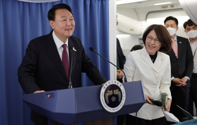 President Yoon Suk-yeol talk to reporters during the flight en route to Seoul at around 1 a.m. on Friday. (Yonhap)