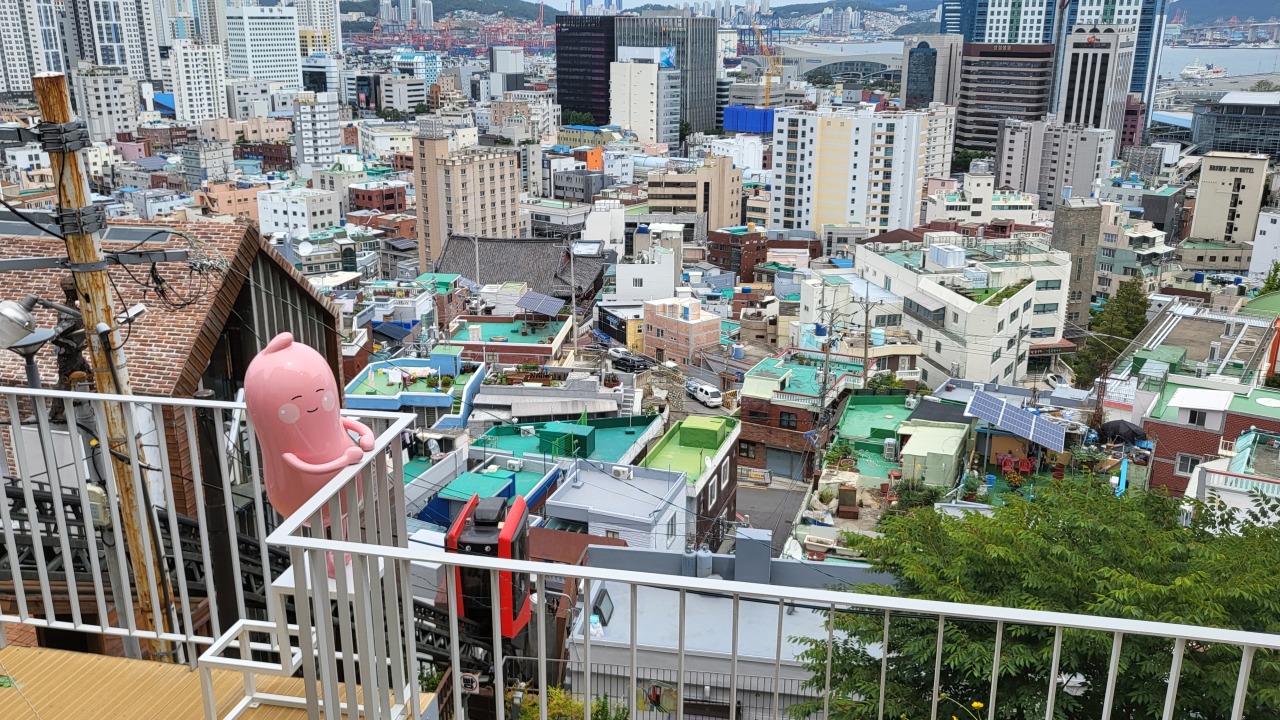 A myeongnan character overlooks the neighborhood from the 163-stairs Monorail in Busan. (Kim Hae-yeon/The Korea Herald)