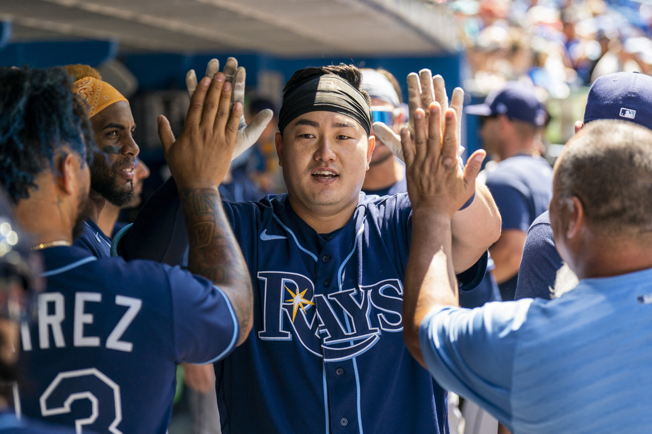 In this USA Today Sports photo via Reuters, Choi Ji-man of the Tampa Bay Rays is greeted by teammates and coaches in the dugout after hitting a solo home run against the Toronto Blue Jays during the top of the fifth inning of a Major League Baseball regular season game at Rogers Centre in Toronto on Sunday. (Reuters)