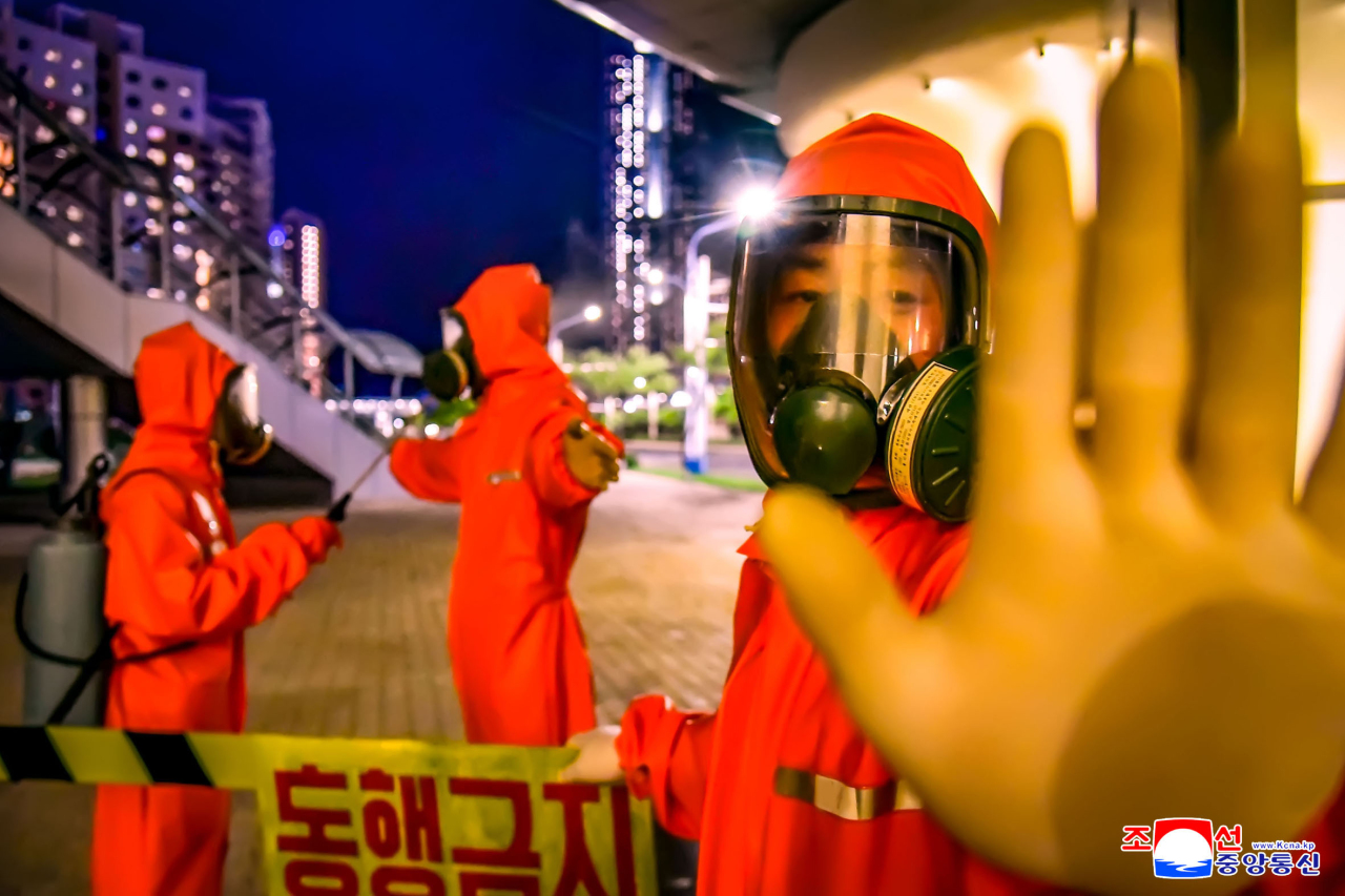 This photo, released by North Korea`s official Korean Central News Agency on June 7, 2022, shows workers sanitizing the capital city of Pyongyang. (Yonhap)