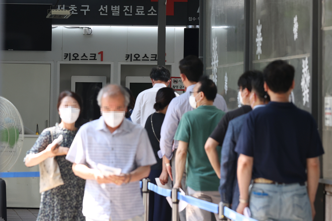 People wait at a COVID-19 testing station in Seoul, Monday. (Yonhap)