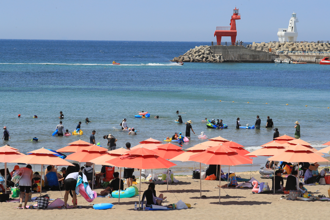 Vacationers enjoy swimming at the Iho Tewoo Beach in Jeju City on Sunday. (Yonhap)