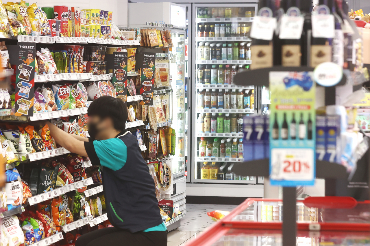 A worker arranges stocks on shelves at a convenience store in Seoul, Wednesday. (Yonhap)