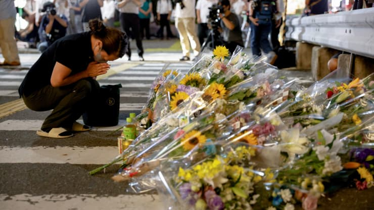 A person prays next to flowers laid at the site where late former Japanese Prime Minister Shinzo Abe was shot while campaigning for a parliamentary election, near Yamato-Saidaiji station in Nara, western Japan last Friday. (Reuters)