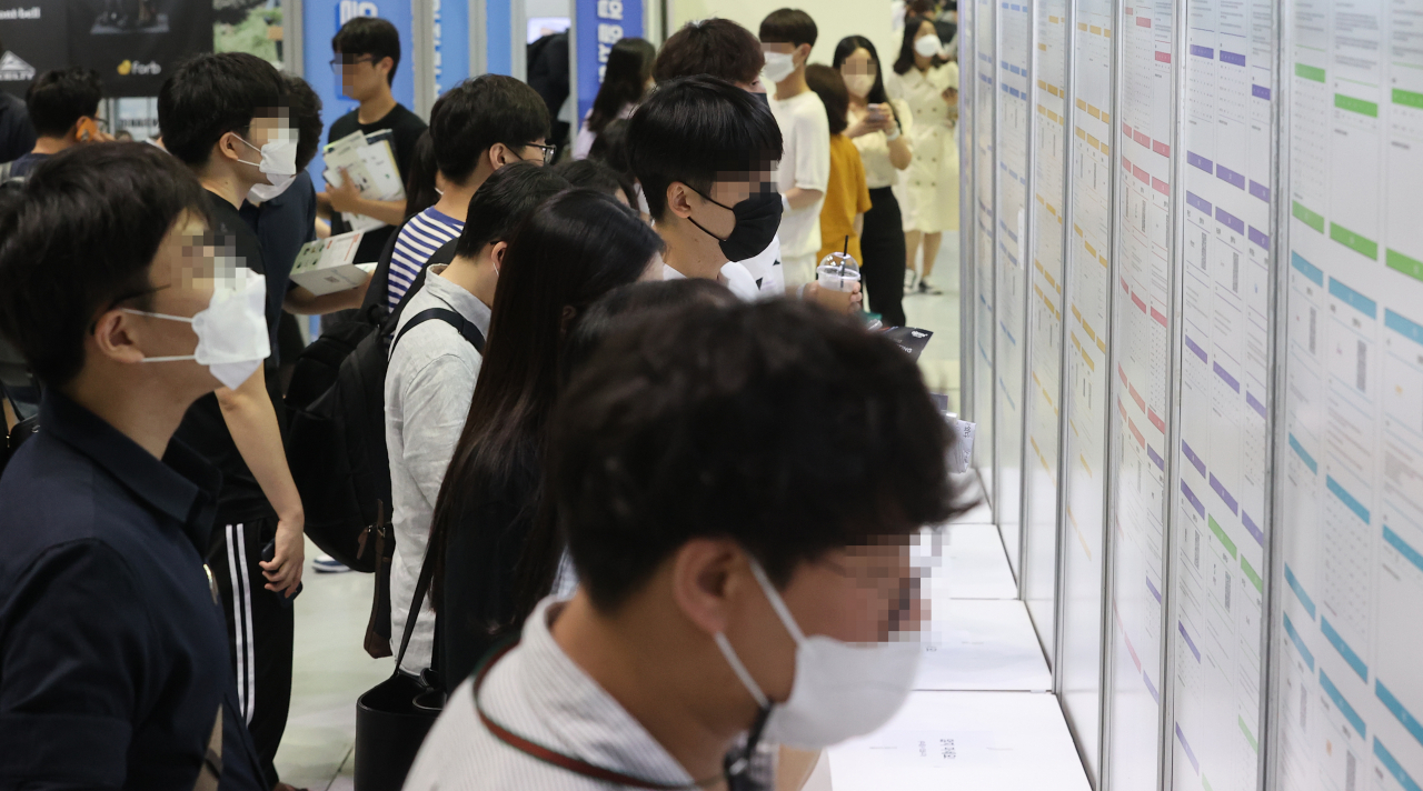 In this file photo, job seekers look at employment information at a job fair held at the Convention and Exhibition Center in southern Seoul last Tuesday. (Yonhap)