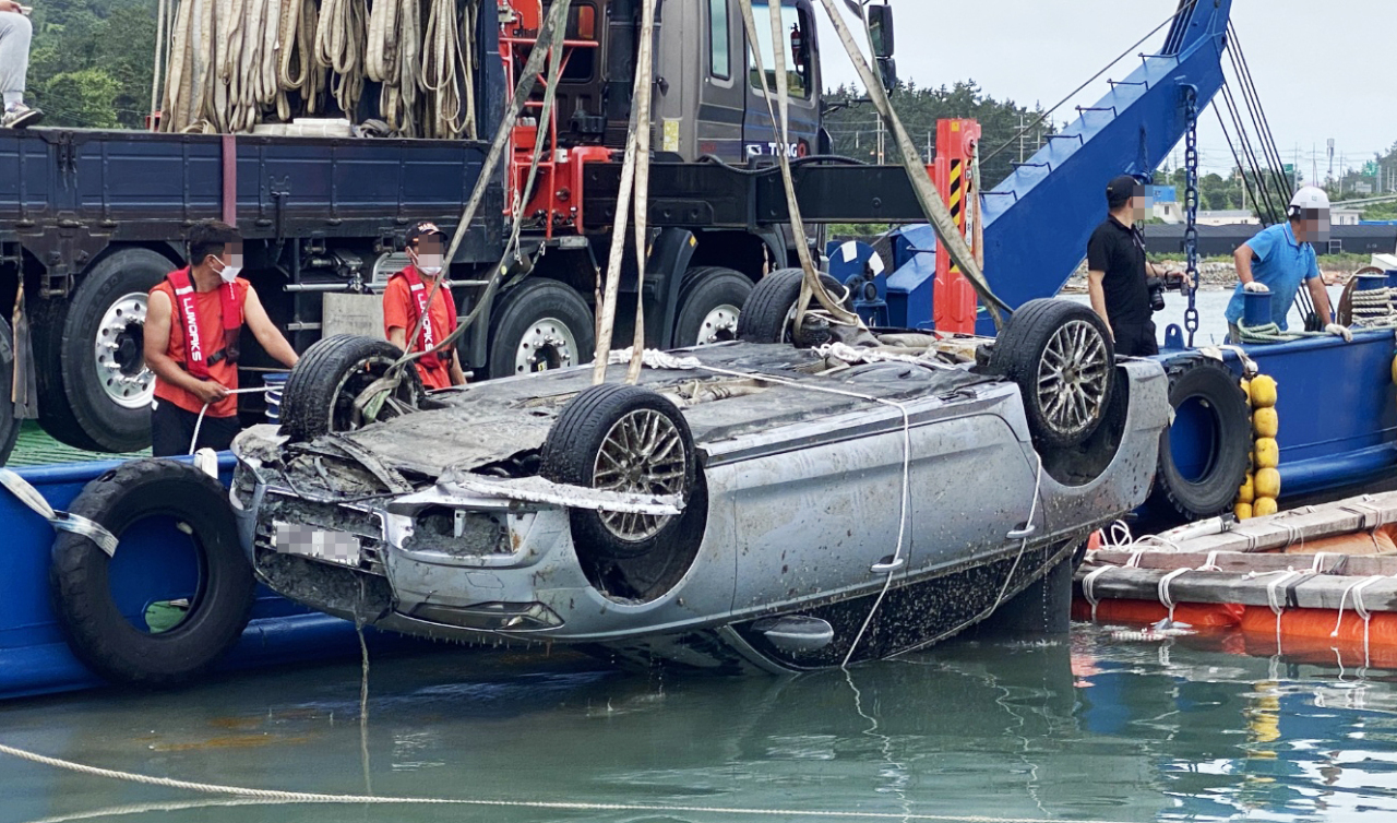 A submerged car which belonged to Cho’s family is being pulled off the shores of Wando, South Jeolla Province on June 29. (Yonhap)