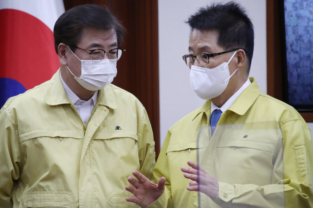 Suh Hoon (left) and Park Jie-won, both of whom served as the director of the National Intelligence Service during the Moon administration, converse during a government meeting in February 2020. (Yonhap)