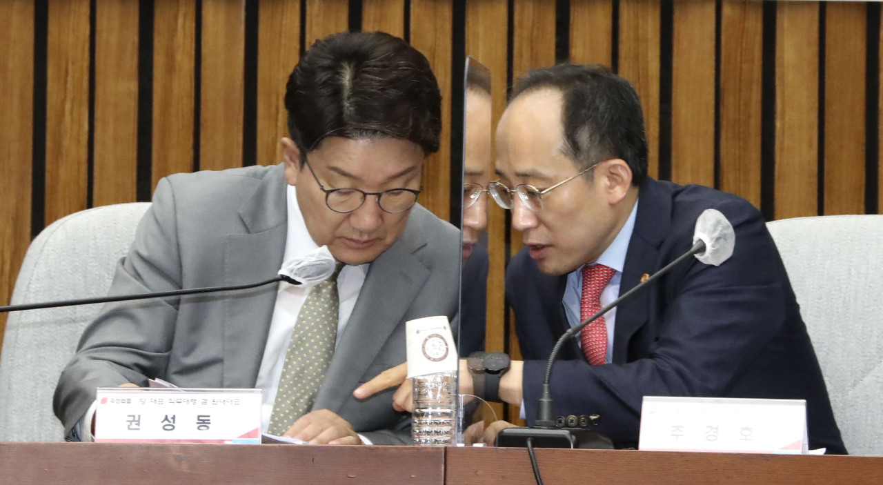 Rep. Kweon Seong-dong (left), floor leader and acting chairman of the ruling People Power Party, speaks with Deputy Prime Minister Choo Kyung-ho (right) during a meeting held at the National Assembly on Monday. (Joint Press Corps)