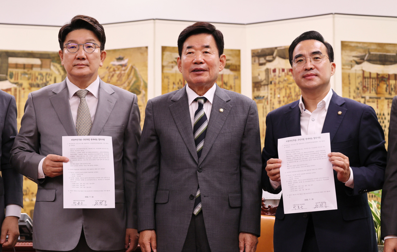 Rep. Kweon Seong-dong (left), floor leader of the ruling People Power Party, poses for a photo Monday with his counterpart Rep. Park Hong-keun (right) of the main opposition Democratic Party of Korea and National Assembly Speaker Kim Jin-pyo (center) in announcing a promise to finalize negotiations on naming new legislative committee chairs by Thursday. (Joint Press Corps)