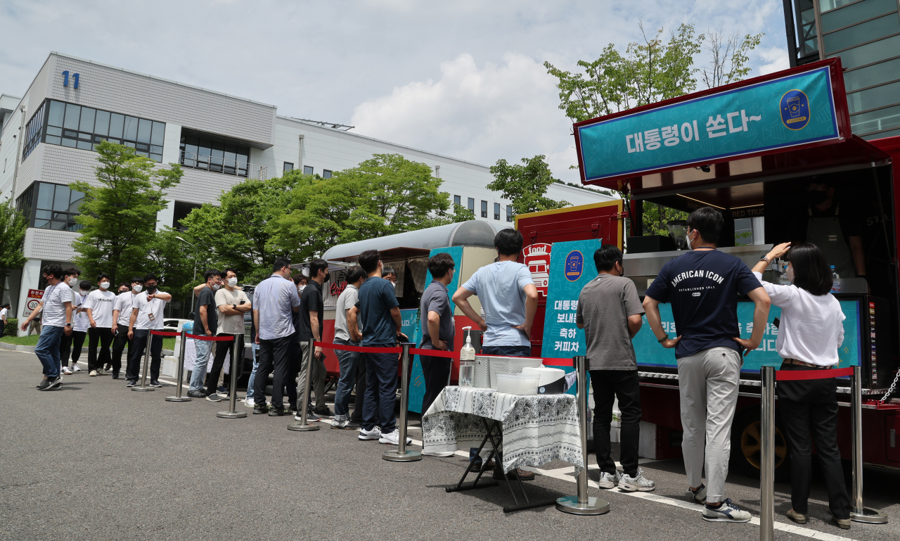 Workers at the Korea Aerospace Research Institute line up for free coffee sent by President Yoon Suk-yeol to celebrate the successful launch of the Nuri rocket on July 6. (Yonhap)