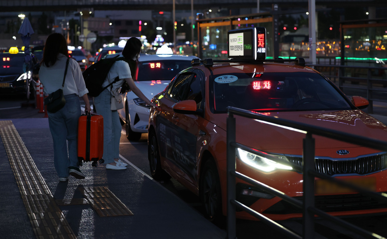 Passengers board a cab at Seoul Station‘s taxi platform on Monday evening. (Yonhap)