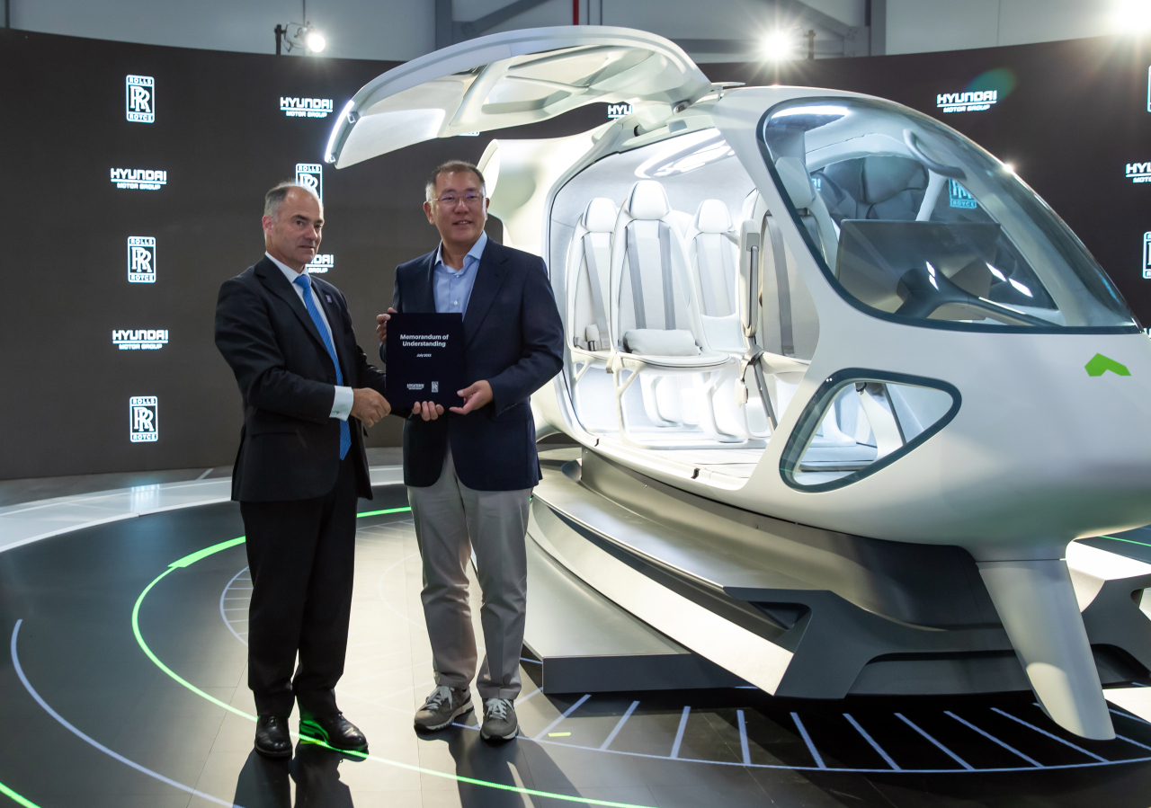 Rolls-Royce CEO Warren East (left) and Hyundai Motor Group Executive Chair Chung Euisun pose for a photo at Supernal’s booth at Farnborough Airshow in Hampshire, England on Tuesday. (Hyundai Motor Group)