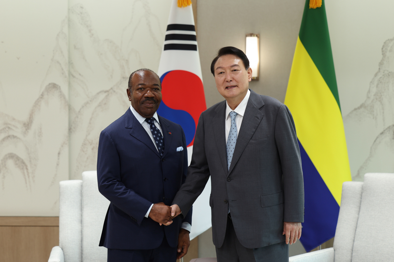 President Yoon Suk-yeol (R) and visiting Gabonese President Ali Bongo Ondimba shake hands before holding summit talks on Wednesday, in this photo provided by the presidential office. (Yonhap)