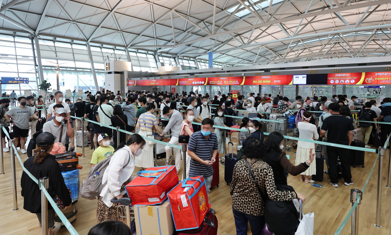 This photo taken on Wednesday, shows outbound travelers at Terminal 1 of Incheon International Airport in Incheon, just west of Seoul, amid the spread of an omicron subvariant. (Yonhap)