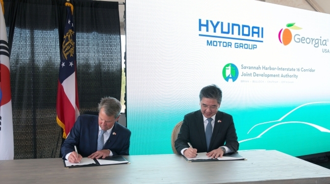 Governor of Georgia Brian Kemp (left) and Hyundai Motor Group CEO Chang Jae-hoon (right) sign a deal at a planned electric vehicle and car battery production site in the US state of Georgia, on Friday local time. (Hyundai Motor Group)
