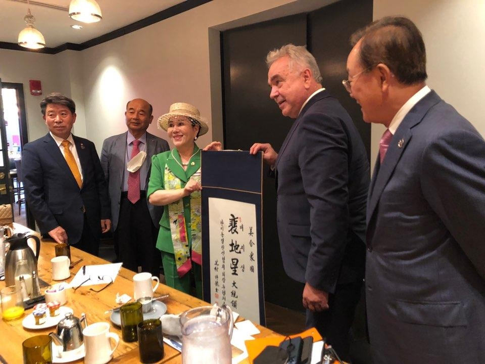 Kurt Campbell, deputy assistant to US President Joe Biden and White House policy coordinator for the Indo-Pacific, is presented with a Korean name for the US president by members of the ROK-US Alliance Friendship Association in Washington on Monday in this photo provided by the association. (ROK-US Alliance Friendship Association)
