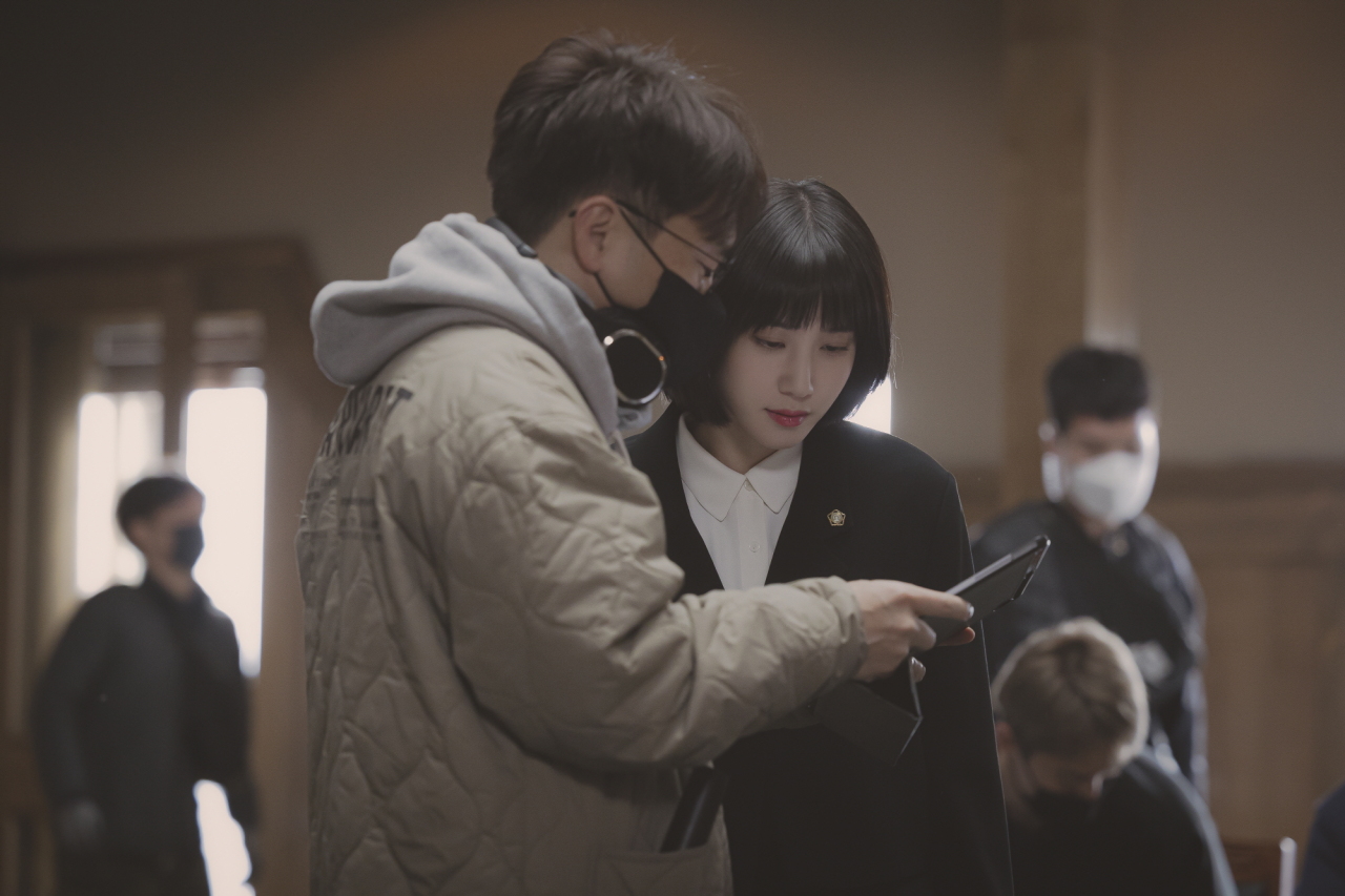 Director Yoo In-sik (left) and actor Park Eun-bin monitor the scene in “Extraordinary Attorney Woo” (ENA)