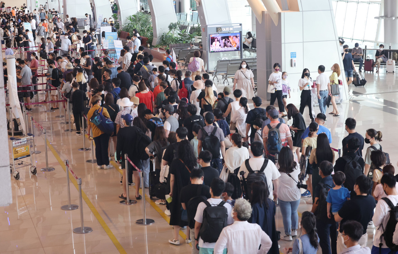 Passengers wait in line at a security checkpoint at Gimpo International Airport’s domestic terminal, in Gangseo-gu, Seoul, Friday. (Yonhap)