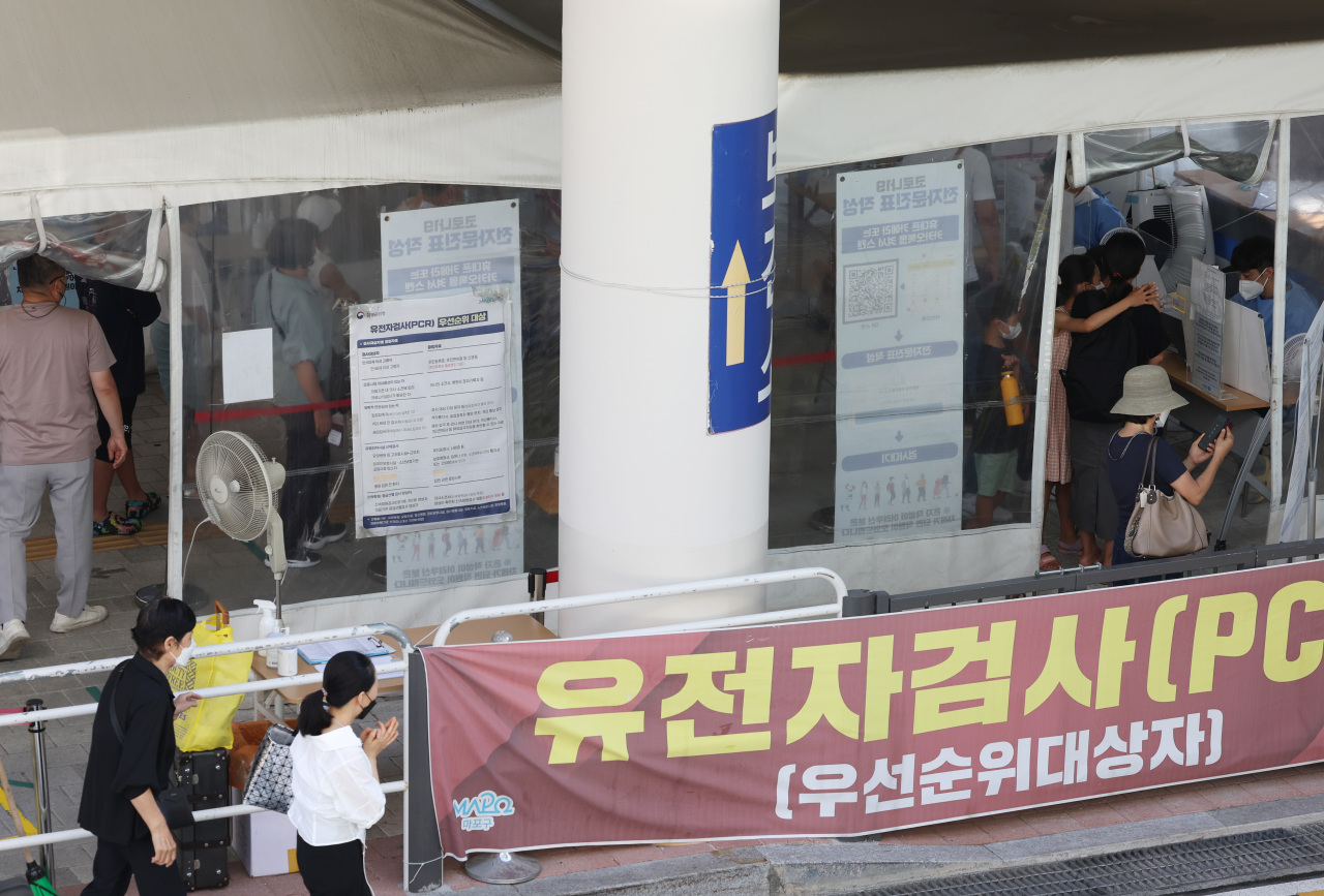 People wait to take coronavirus tests at a screening clinic in Seoul's Mapo Ward on Friday. (Yonhap)