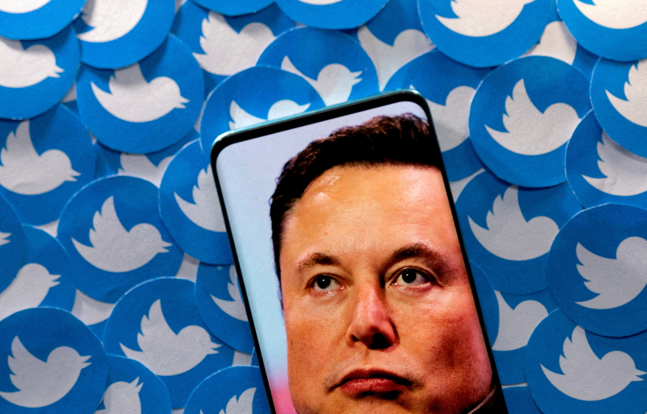 An image of Elon Musk is seen on smartphone placed on printed Twitter logos in this picture illustration taken April 28. (Reuters-Yonhap)