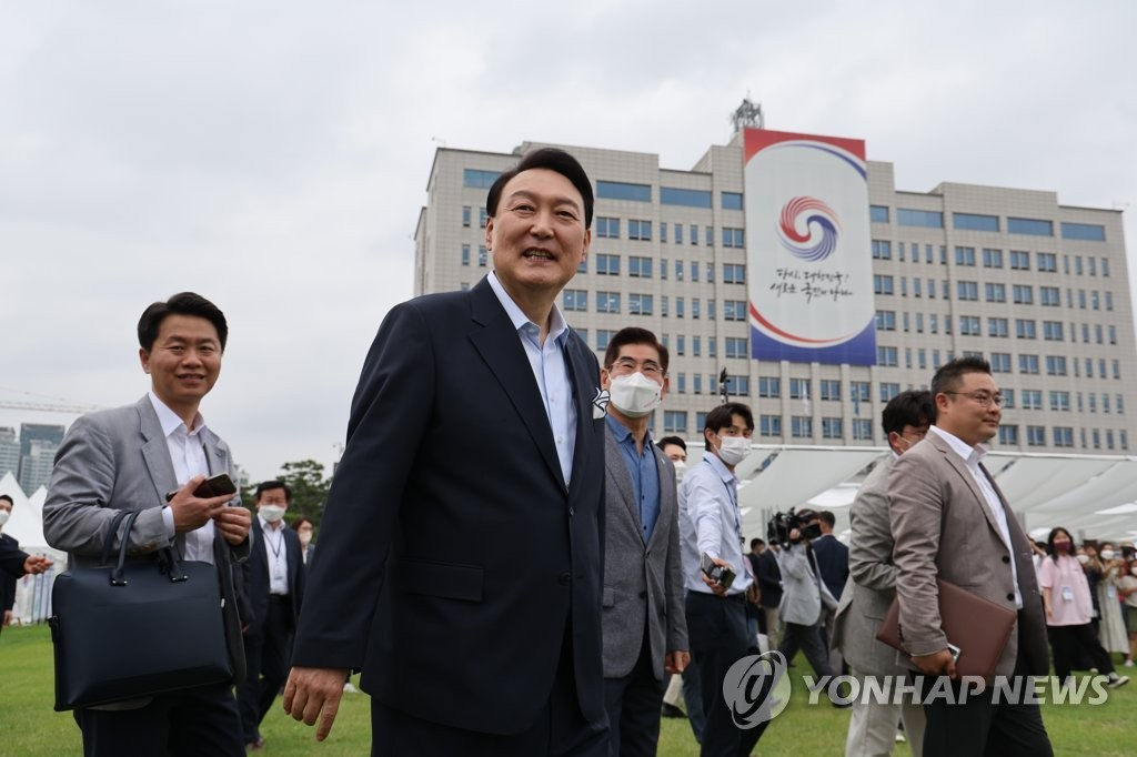 President Yoon Suk-yeol tours flea market booths in the front yard of the presidential office in Seoul's Yongsan district on June 19, 2022. (Yonhap)